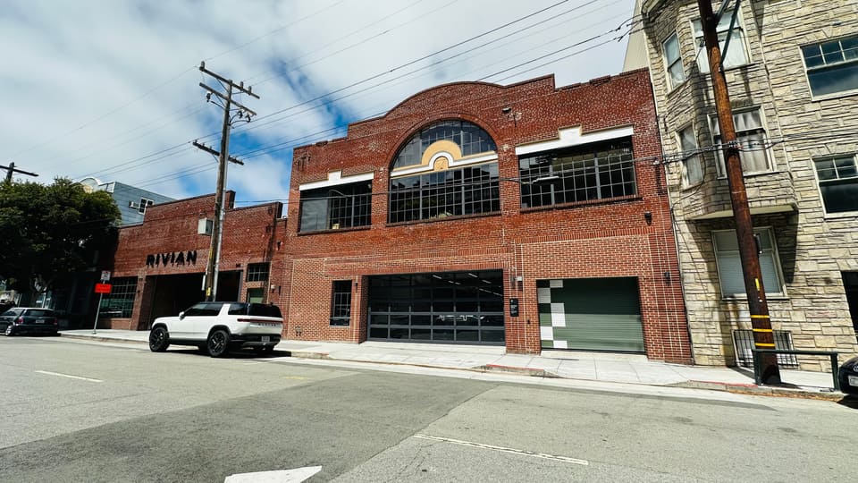 A brick warehouse with a large arched window in Hayes Valley, now occupied by a car showroom.