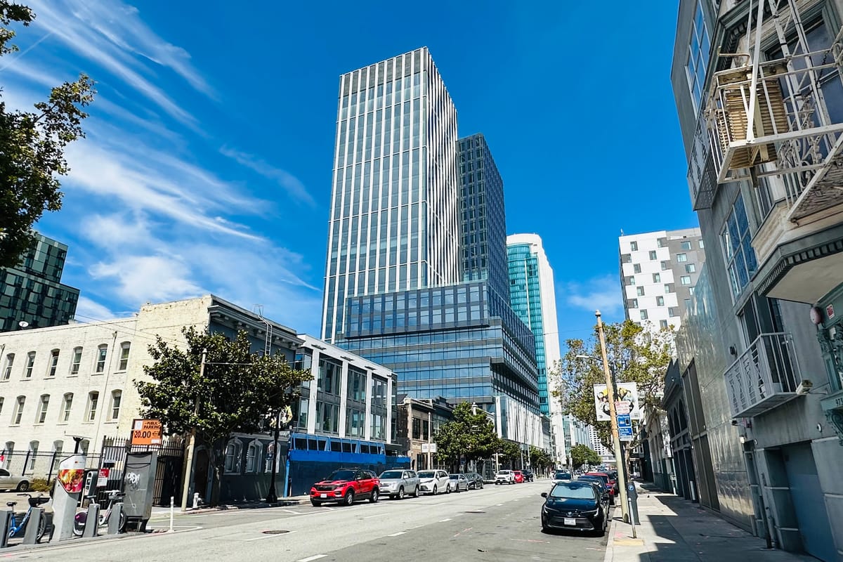 A wide SoMa street in San Francisco looking toward the district's modern high-rise towers, with low-rise buildings in the foreground.
