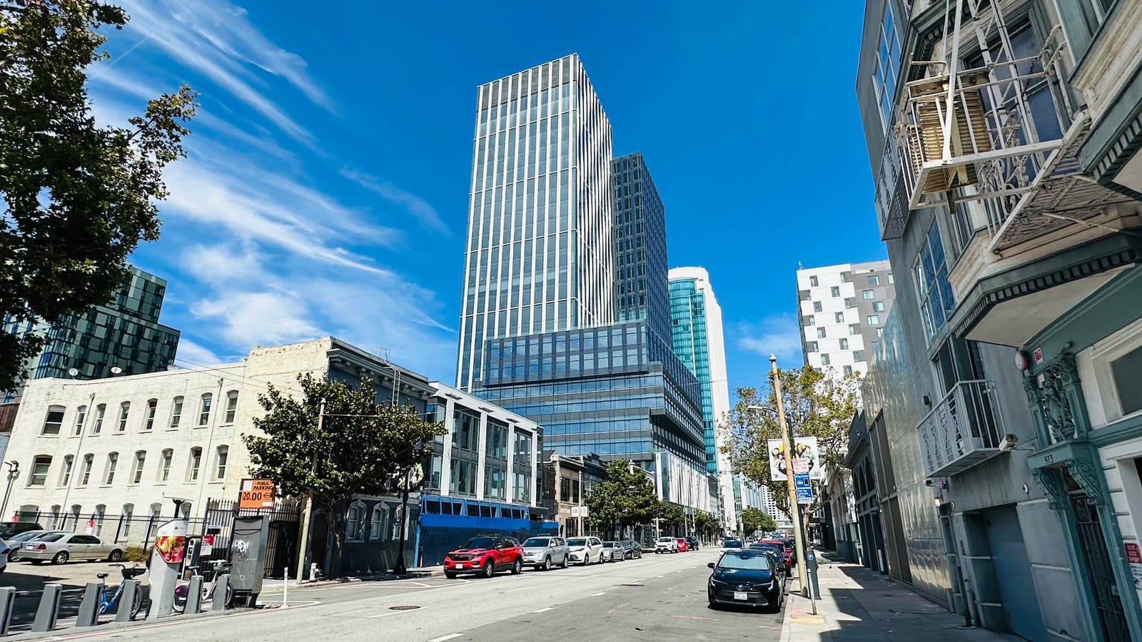 A wide SoMa street in San Francisco looking toward the district's modern high-rise towers, with low-rise buildings in the foreground.